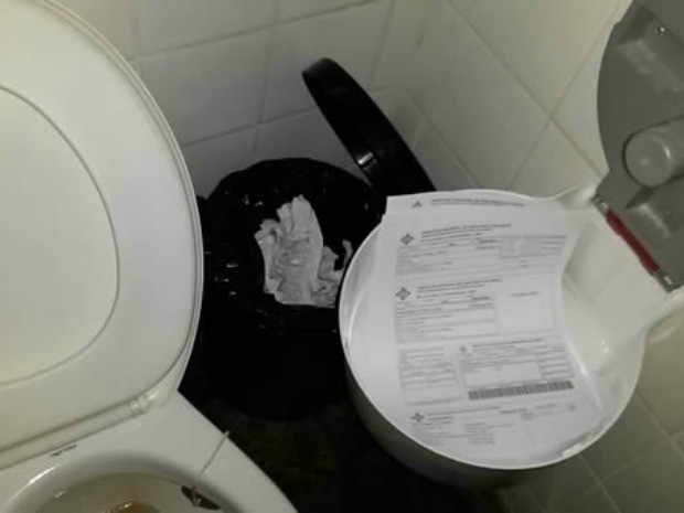 Rascunhos ocupam suporte para papel higiênico no banheiro masculino (Foto: Gazeta Central/Reprodução)