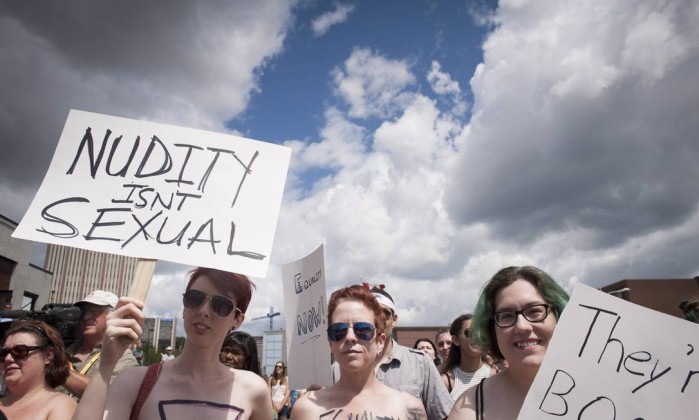 Com cartazes nas mãos, centenas de mulheres marcharam com os seios à mostra neste sábado, em Ontário, no Canadá - Hannah Yoon / AP