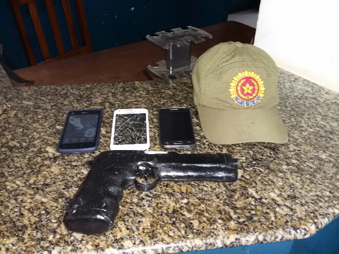 arma e celulares encontrada com os meliantes.