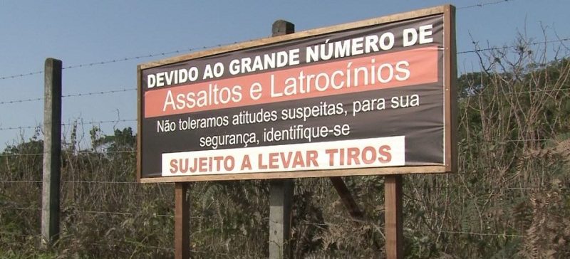 Placa:"SUJEITO A LEVAR TIROS"