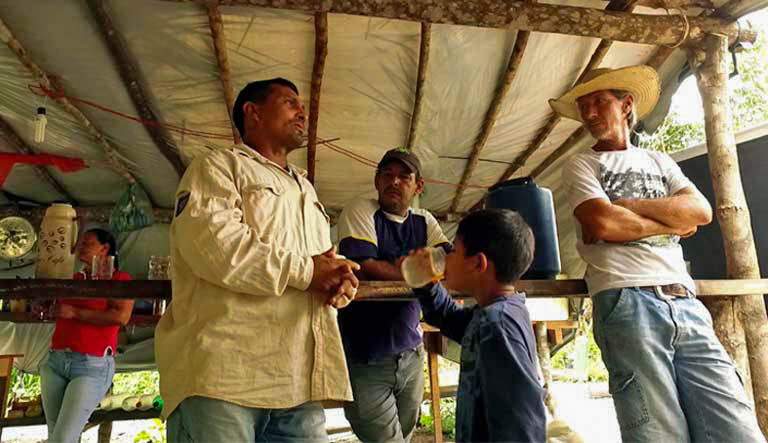 Alenquer (à esquerda) com camponeses no assentamento “KM Mil”. Logo após essa foto ter sido tirada, bandidos armados invadiram o acampamento, dizendo aos sem-terra que se não desistissem da reivindicação à terra, as ameaças logo se transformariam em violência. (Foto: Thais Borges).