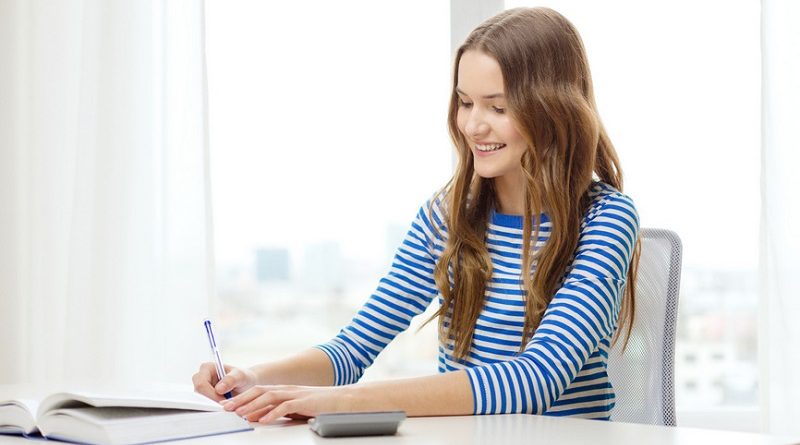 education and home concept - happy smiling student girl with notebook, calculator and book