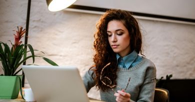 College student working on laptop at desk.