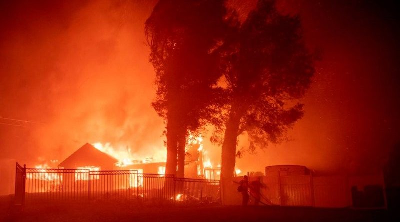 (FILES) In this file photo taken on October 31, 2019 a firefighter works the scene as wind-whipped flames and embers light multiple homes on fire during the Hillside fire in the North Park neighborhood of San Bernardino, California. - US President Donald Trump threatened once again on November 3, 2019 to withhold federal aid from California after its Democratic governor criticized his environmental policies.Over the past two weeks, fires have ravaged nearly 100,000 acres (40,000 hectares) in the sprawling western state, where fighters on Sunday were battling the Maria Fire, about 60 miles northwest of Los Angeles. (Photo by Josh Edelson / AFP)