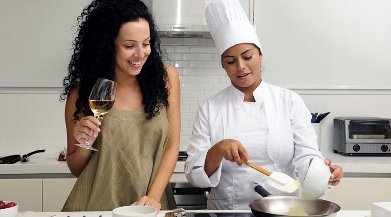 Cookery course: pouring wine into a pan with risotto