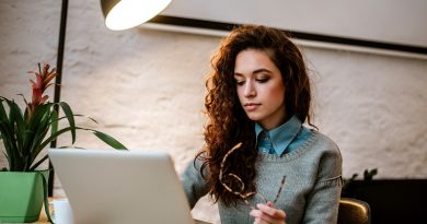 College student working on laptop at desk.