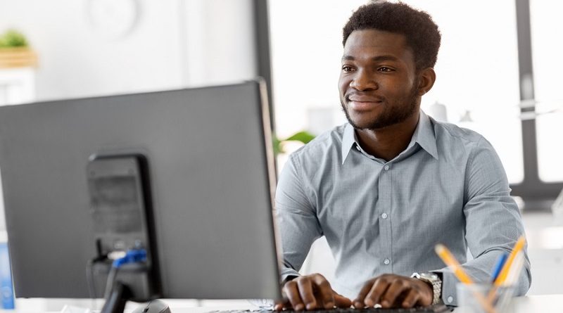 business, people and technology concept - african american businessman with computer working at office