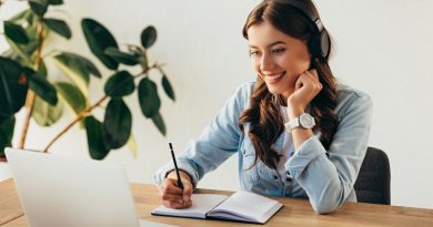 portrait of young smiling woman in headphones taking part in webinar in office