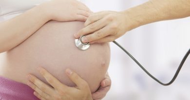 pregnant woman and hand with stethoscope