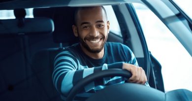 Driving gets him so excited. Shot of a handsome African man sitting in a car holding steering wheel smiling happily to the camera