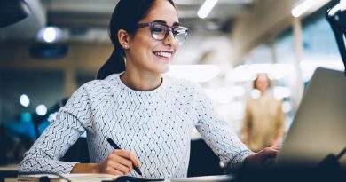 Cheerful businesswoman excited with accomplished project successfully monitoring news online via netbook, smiling female administrative manager happy about increasing company income making report