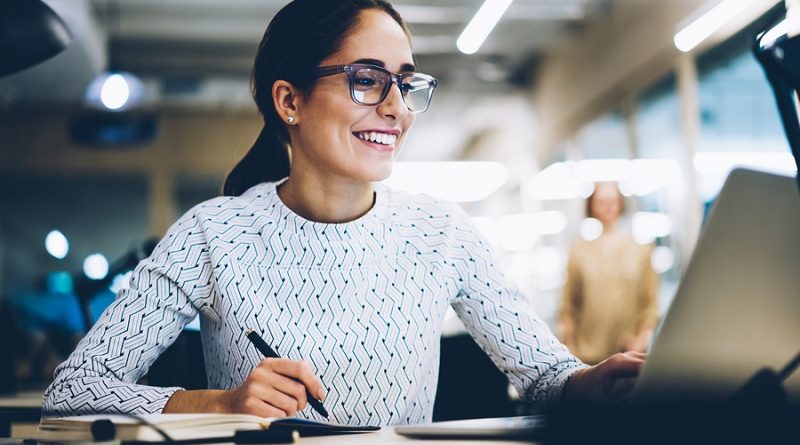 Cheerful businesswoman excited with accomplished project successfully monitoring news online via netbook, smiling female administrative manager happy about increasing company income making report
