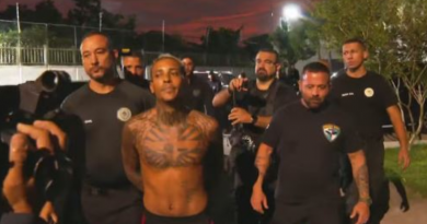 Policiais com material apreendido na casa de MC Poze do Rodo — Foto: Gabriel de Paiva / Agência O Globo