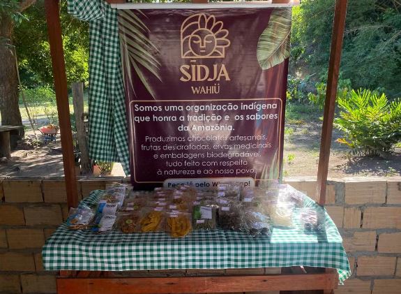 Pequeno expositor que fica na casa de Katyana com alguns dos produtos da Sidjä Wahiü. — Foto: Juliana Bessa / g1