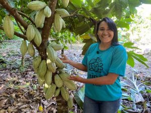 Katyana mostrou um dos pés de cacau mais novos do cultivo. — Foto: Juliana Bessa / g1
