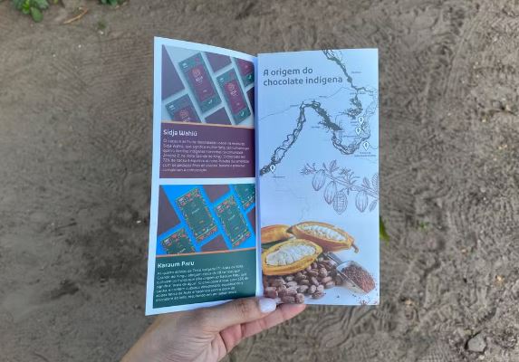 Cartilha mostra os cinco chocolates indígenas da volta grande do Xingu, criados a partir das contrapartidas que a concessionária de Belo Monte realiza na região por conta dos impactos socioambientais. Na foto, duas das marcas: Sidjä Wahiü e Karaum Paru. Mapa ao lado também mostra onde a Jericoá e as outras comunidades estão localizadas. — Foto: Juliana Bessa / g1