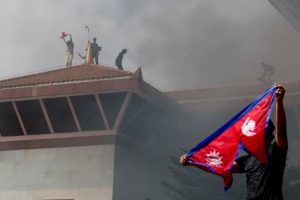 Manifestantes comemoram com bandeira do Nepal após entrar em complexo do Parlamento nepalês durante protesto contra o governo em 9 de setembro de 2025. — Foto: REUTERS/Adnan Abidi